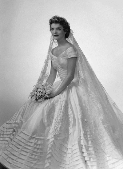 Jacqueline Bouvier The future first lady (and fashion icon) wore a voluminous ivory silk taffeta gown by the designer Ann Lowe when she married John F. Kennedy in 1953. A portrait neckline and wide, embellished skirt emphasized Jackie's small waist, and an heirloom lace veil, which originally belonged to her grandmother, completed the super-romantic ensemble.